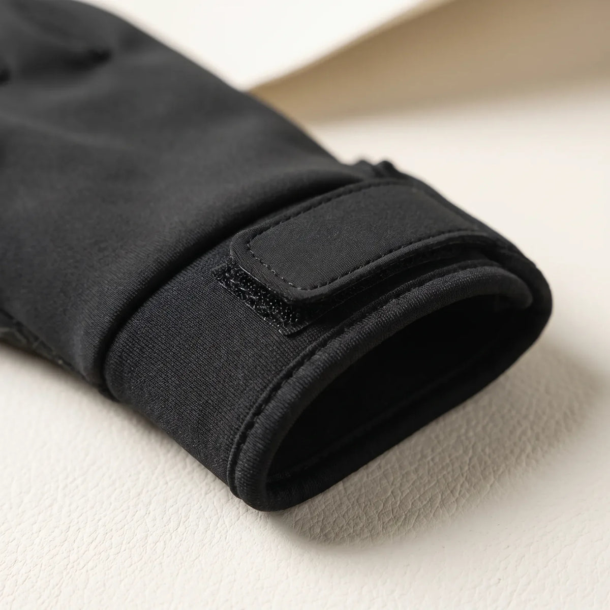Hook-and-loop strap and elastic cuff at the wrist